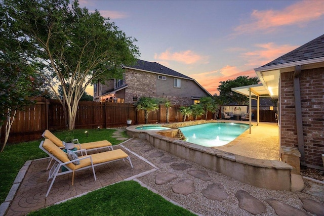 650 Ledge Stone Dr, Austin, TX 78737 - pool at dusk featuring a patio area, a fenced backyard, and a pool with connected hot tub