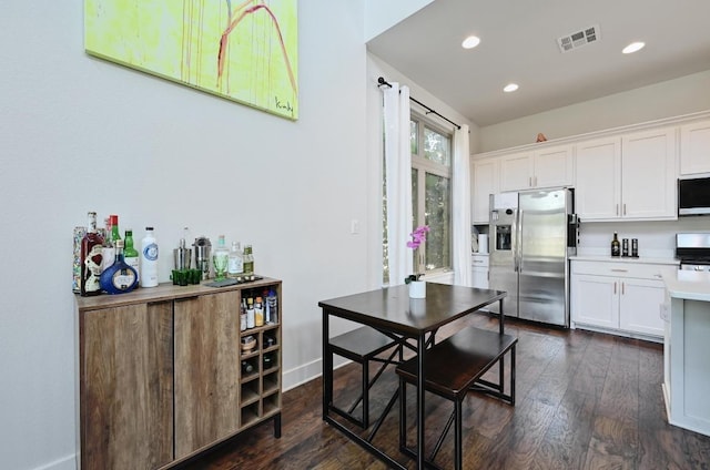 kitchen featuring stainless steel appliances, light countertops, white cabinetry, dark wood-type flooring, and recessed lighting