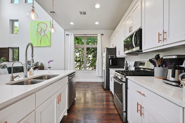 kitchen with stainless steel appliances, a sink, light countertops, dark wood-type flooring, and white cabinets