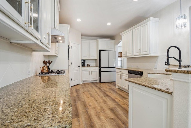 12907 Gordons Hvn, San Antonio, TX 78253 - kitchen featuring freestanding refrigerator, custom range hood, white cabinetry, light stone countertops, and stainless steel gas stovetop