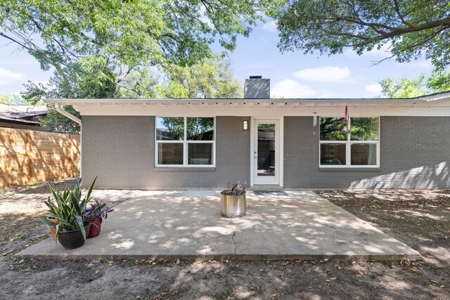 8604 Primrose Ln, Austin, TX 78757 - rear view of house with a chimney, brick siding, and a patio area