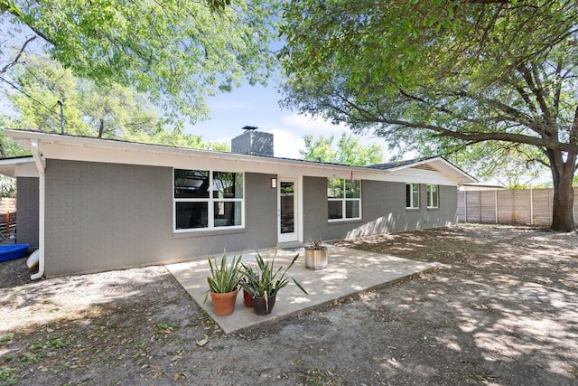 8604 Primrose Ln, Austin, TX 78757 - rear view of property featuring a chimney, a patio area, and brick siding