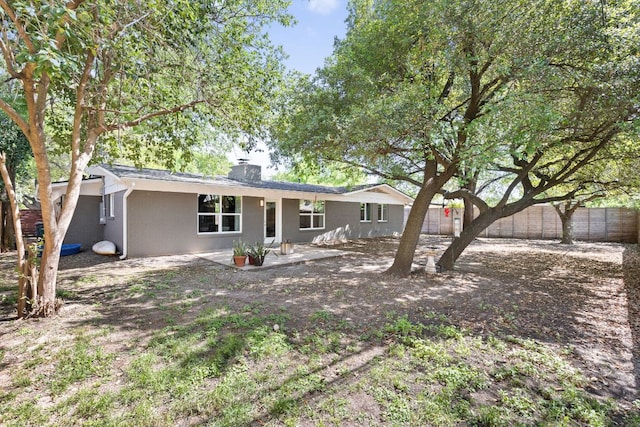 8604 Primrose Ln, Austin, TX 78757 - rear view of property featuring a fenced backyard, a chimney, and stucco siding