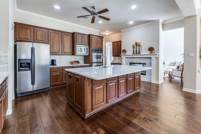 402 Palos Verdes Dr, Lakeway, TX 78734 - kitchen featuring stainless steel appliances, ceiling fan, light countertops, dark wood-type flooring, and a glass covered fireplace
