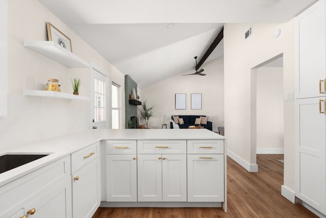 9005 Quail Creek Dr, Austin, TX 78758 - kitchen with a peninsula, white cabinetry, open shelves, and light wood finished floors