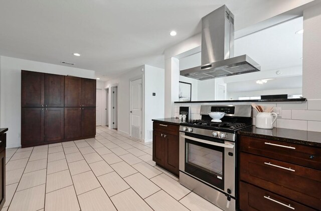 4607 S Forest Dr, Austin, TX 78745 - kitchen featuring island range hood, stainless steel gas stove, dark brown cabinetry, light tile patterned floors, and recessed lighting