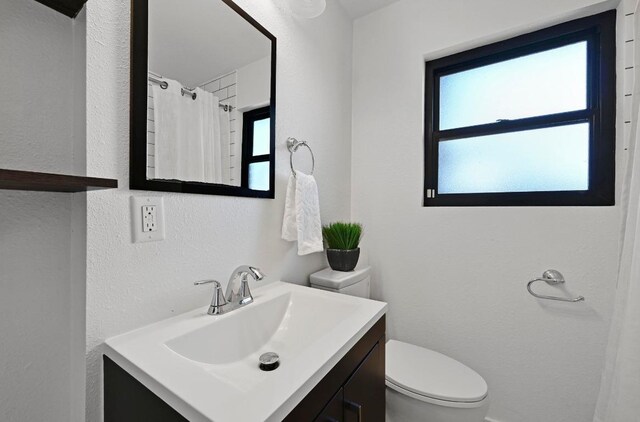 4607 S Forest Dr, Austin, TX 78745 - full bath with toilet, healthy amount of natural light, vanity, a textured wall, and a shower with curtain