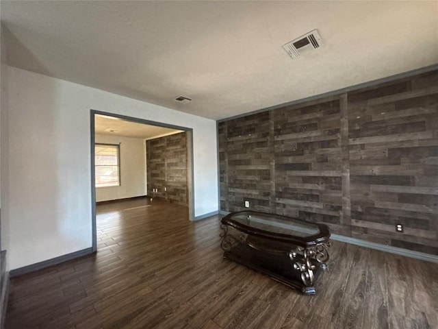unfurnished room featuring wood finished floors, baseboards, and visible vents