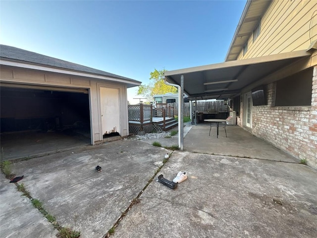 view of patio featuring a deck, a garage, and concrete driveway