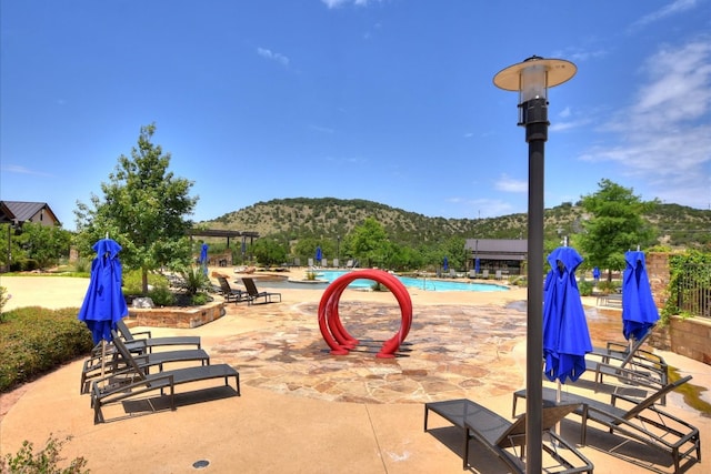 view of patio featuring a community pool and a mountain view