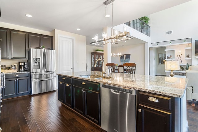 2348 Centennial Loop, Round Rock, TX 78665 - kitchen with appliances with stainless steel finishes, a sink, light stone countertops, dark wood finished floors, and open floor plan