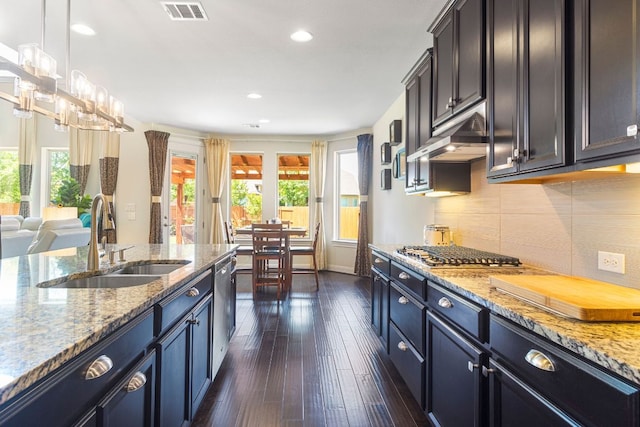2348 Centennial Loop, Round Rock, TX 78665 - kitchen with a sink, stainless steel appliances, dark wood finished floors, tasteful backsplash, and light stone counters