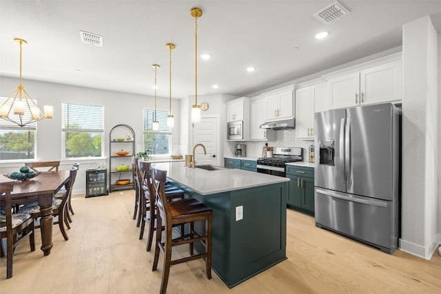 200 W 56th St Unit 4102, Austin, TX 78751 - kitchen with stainless steel appliances, beverage cooler, light wood-style floors, a chandelier, and an island with sink
