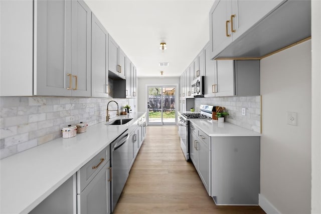 2702 Irish Bend Dr, Austin, TX 78745 - kitchen featuring gray cabinets, light countertops, visible vents, and stainless steel appliances