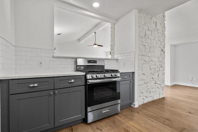 6107 Amber Pass, Austin, TX 78745 - kitchen with stainless steel gas stove, gray cabinetry, backsplash, and light countertops