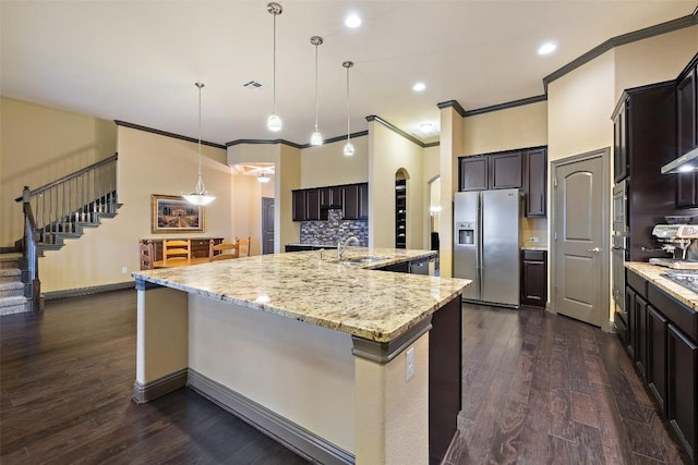5612 Cherokee Draw Rd, Austin, TX 78738 - kitchen with stainless steel appliances, crown molding, a large island with sink, backsplash, and light stone counters