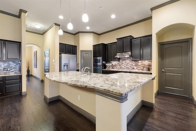5612 Cherokee Draw Rd, Austin, TX 78738 - kitchen featuring appliances with stainless steel finishes, arched walkways, crown molding, backsplash, and a breakfast bar