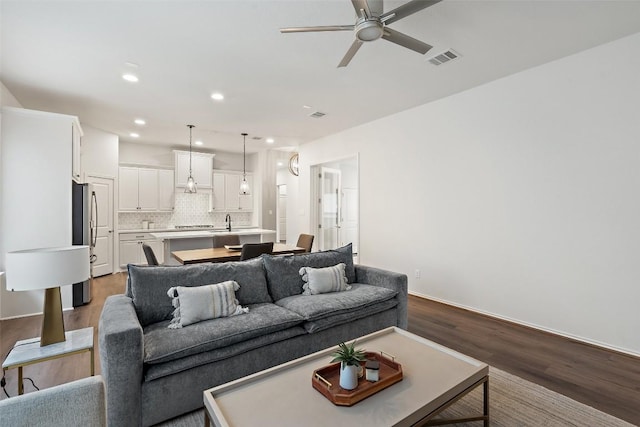 living area with wood finished floors, a ceiling fan, visible vents, and recessed lighting