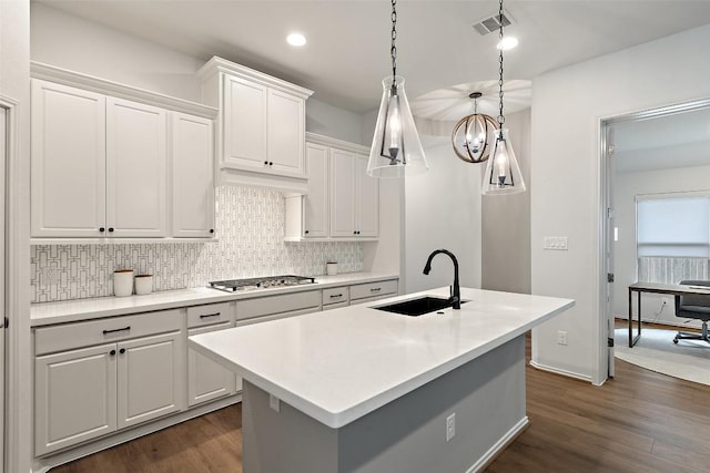 kitchen with tasteful backsplash, dark wood-style flooring, white cabinetry, and a sink