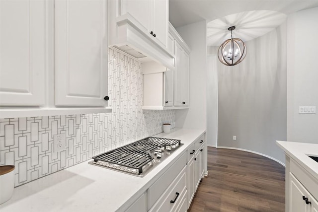 kitchen featuring light countertops, white cabinetry, decorative backsplash, and a notable chandelier