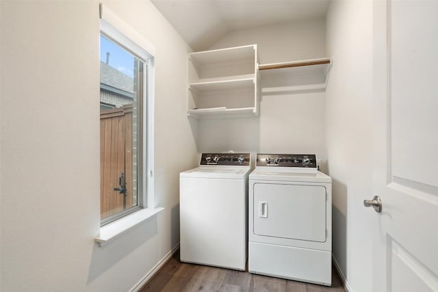 laundry area with wood finished floors, washing machine and clothes dryer, baseboards, and laundry area
