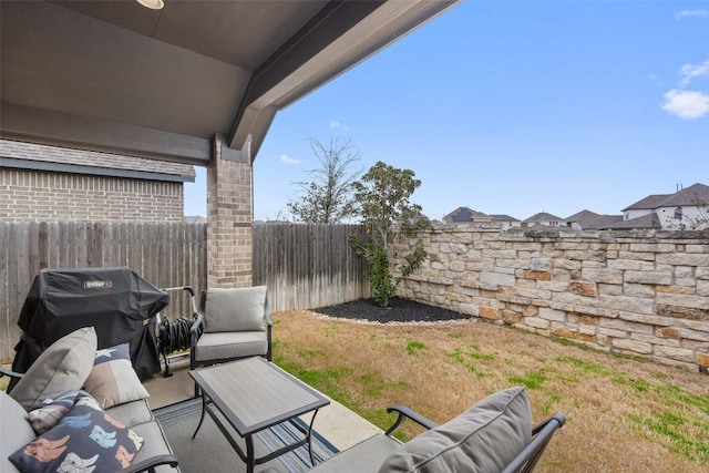 view of patio featuring a fenced backyard, a grill, and an outdoor living space