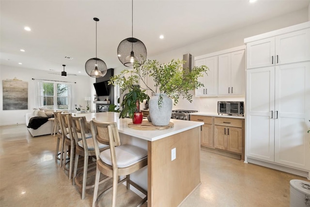 5701 Tura Ln Unit 1, Austin, TX 78721 - kitchen featuring recessed lighting, a kitchen island, open floor plan, light countertops, and a kitchen bar
