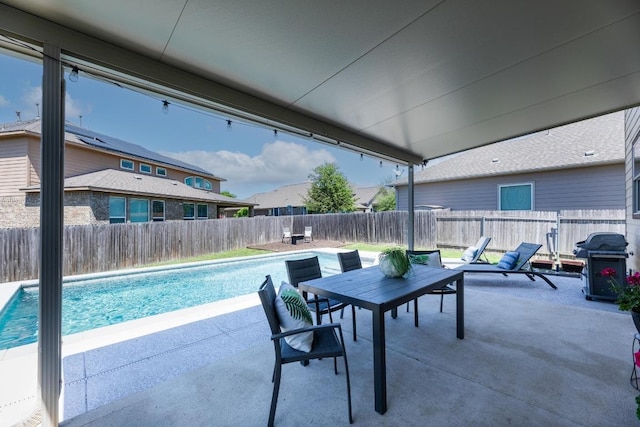 view of swimming pool featuring a patio area, a fenced backyard, grilling area, outdoor dining area, and a fenced in pool