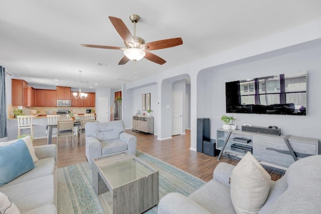 5812 Pescia St, Round Rock, TX 78665 - living area featuring light wood finished floors, ceiling fan, arched walkways, a chandelier, and baseboards