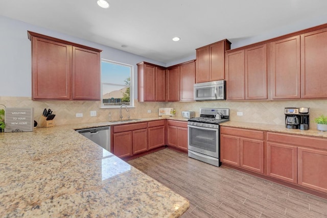 5812 Pescia St, Round Rock, TX 78665 - kitchen featuring appliances with stainless steel finishes, a sink, light stone countertops, decorative backsplash, and recessed lighting