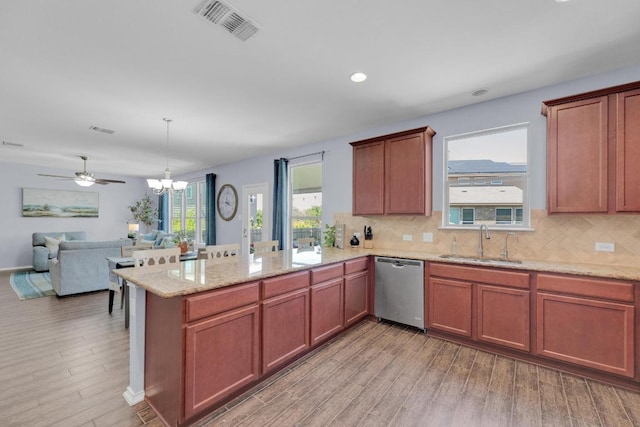 5812 Pescia St, Round Rock, TX 78665 - kitchen featuring stainless steel dishwasher, a sink, a peninsula, light wood-style floors, and recessed lighting