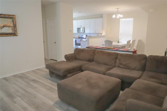 70 Snowy Plover Ln, Leander, TX 78641 - living room featuring a chandelier, light wood-style floors, and baseboards