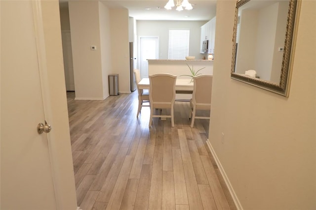 70 Snowy Plover Ln, Leander, TX 78641 - dining space featuring light wood-style flooring, baseboards, and a chandelier