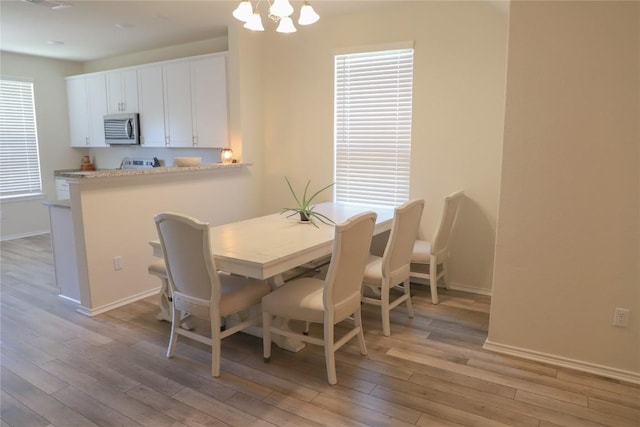 70 Snowy Plover Ln, Leander, TX 78641 - dining space with light wood-style floors, baseboards, and a chandelier