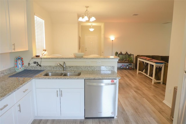 70 Snowy Plover Ln, Leander, TX 78641 - kitchen with dishwasher, a sink, a peninsula, white cabinetry, and light wood finished floors