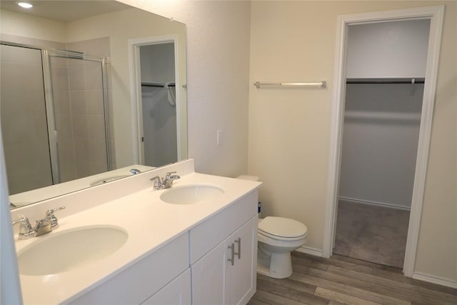 70 Snowy Plover Ln, Leander, TX 78641 - bathroom featuring a spacious closet, toilet, wood finished floors, a shower stall, and double vanity