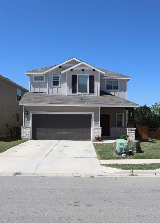 70 Snowy Plover Ln, Leander, TX 78641 - view of front of house with an attached garage, board and batten siding, driveway, and stone siding