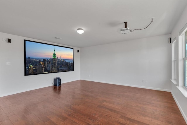 spare room featuring baseboards, visible vents, and wood finished floors