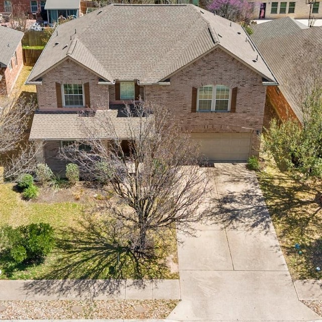view of front of house with a garage, roof with shingles, and brick siding