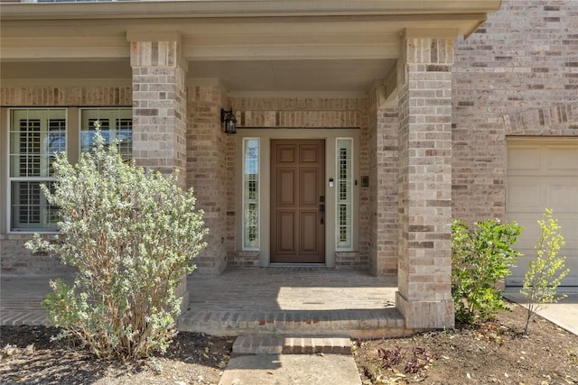 property entrance with a porch and brick siding