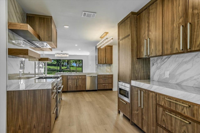 6304 Lost Horizon Dr, Austin, TX 78759 - kitchen featuring stainless steel appliances, decorative backsplash, light wood-type flooring, brown cabinets, and recessed lighting