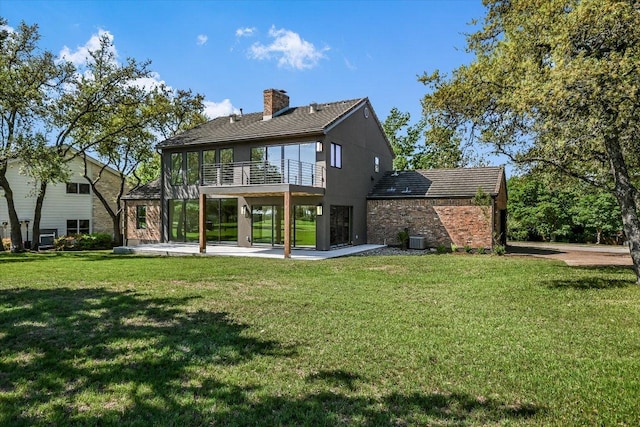 6304 Lost Horizon Dr, Austin, TX 78759 - rear view of property featuring a balcony, a yard, a patio, a chimney, and brick siding