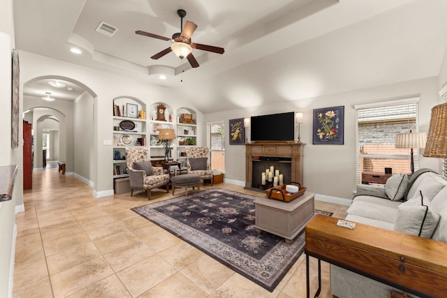 215 Choke Canyon Ln, Georgetown, TX 78628 - living room featuring ceiling fan, arched walkways, built in features, a tray ceiling, and recessed lighting