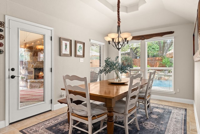 215 Choke Canyon Ln, Georgetown, TX 78628 - dining room featuring healthy amount of natural light, a chandelier, light tile patterned floors, vaulted ceiling, and a stone fireplace