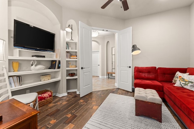 215 Choke Canyon Ln, Georgetown, TX 78628 - living area featuring arched walkways, ceiling fan, hardwood / wood-style flooring, and built in shelves