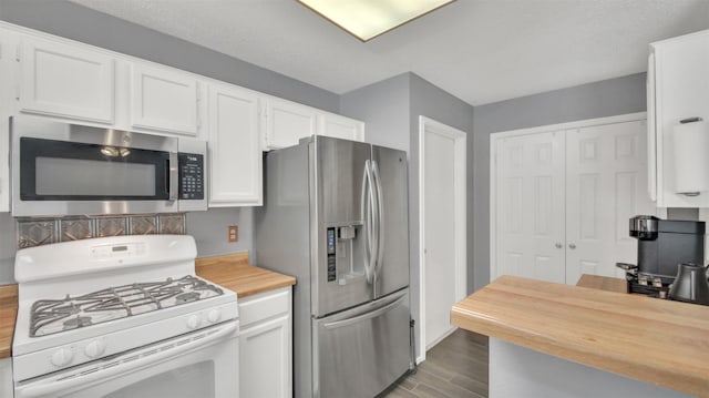 812 Saunders Dr, Round Rock, TX 78664 - kitchen with stainless steel appliances, wooden counters, white cabinets, dark wood-style flooring, and decorative backsplash