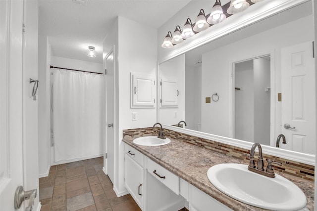 812 Saunders Dr, Round Rock, TX 78664 - full bathroom featuring double vanity, backsplash, stone finish floors, and a shower with shower curtain