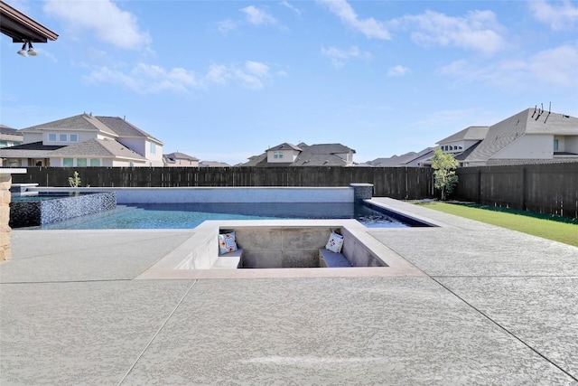 view of swimming pool with a residential view, a pool with connected hot tub, and a fenced backyard