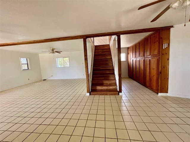 1530 Trailridge Dr, Canyon Lake, TX 78133 - unfurnished living room featuring a ceiling fan, stairs, light tile patterned floors, and wood walls