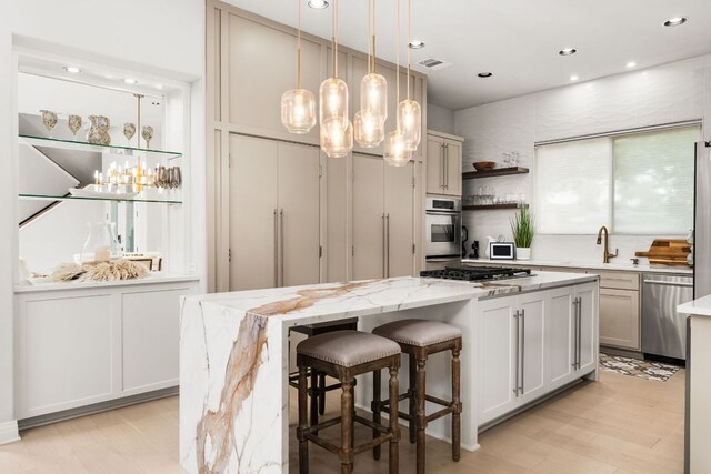 kitchen featuring open shelves, an inviting chandelier, gas stovetop, stainless steel dishwasher, and a kitchen island